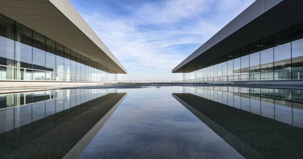 Façades vitrées d'une architecture contemporaine reflétant le ciel, illustrant le métier de vitrier auto-entrepreneur