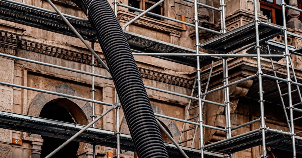 Échafaudage installé devant une façade en pierre en cours de ravalement
